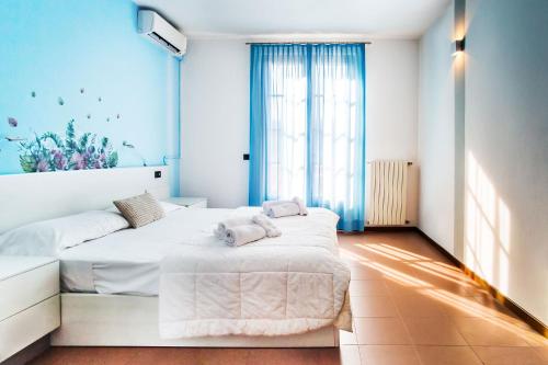 a bedroom with two beds and a large window at Hotel Il Castello in Pozzolengo
