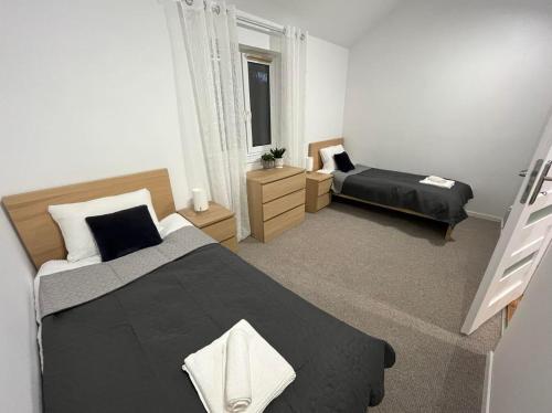 a bedroom with two beds and a window at Mazurska Osada Domki in Rydzewo