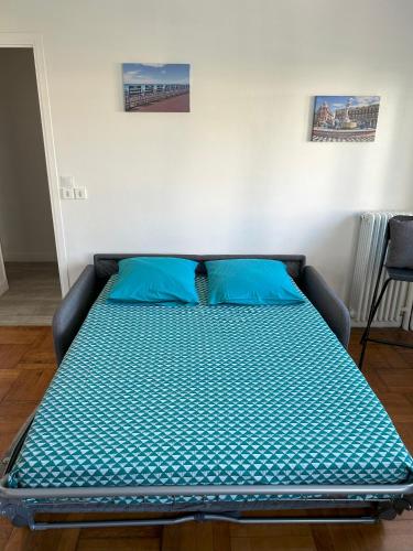 - un lit avec des oreillers bleus dans l'établissement Le 29 Promenade des Anglais - Golden Square, à Nice