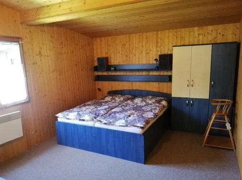1 dormitorio con 1 cama en una habitación de madera en Chata U Losinky, Bukovická 645, Velké Losiny en Velké Losiny
