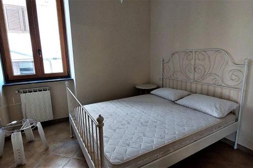 a white bed in a room with two windows at Il Giardino degli aranci in Pisciotta