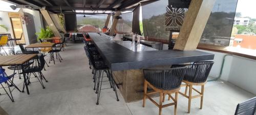 a bar in a restaurant with tables and chairs at Ximena Hotel Boutique in Sayulita