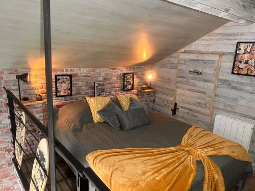 a bed in a room with a brick wall at Top Loft Perles 4 des Châteaux in Mer