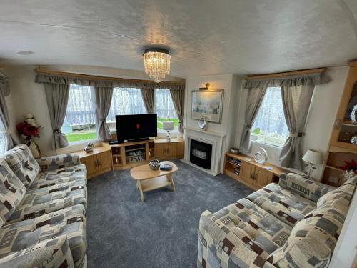 a living room with two couches and a tv at Walsh's Holiday Park - Sapphire - Coastal Caravan Breaks in Lincolnshire