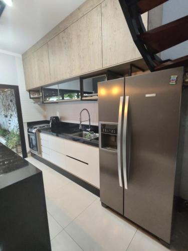 a kitchen with a stainless steel refrigerator and a sink at Sobrado para relaxar in Tatuí