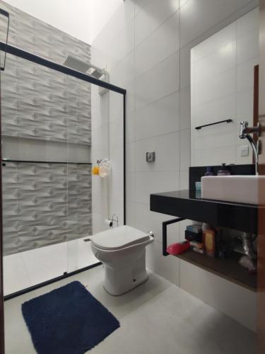a bathroom with a shower and a toilet and a sink at Sobrado para relaxar in Tatuí