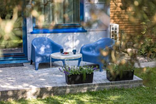 a patio with two chairs and a table and some flowers at Atpūtys in Palanga