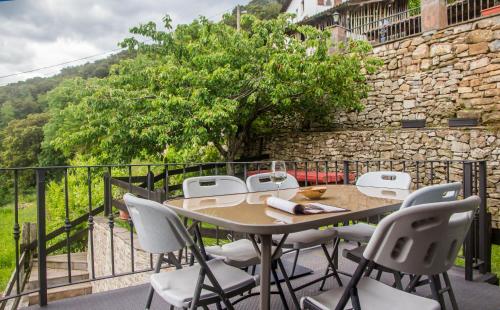 - Balcón con mesa y sillas y pared de piedra en Armaño Rural, en Tama