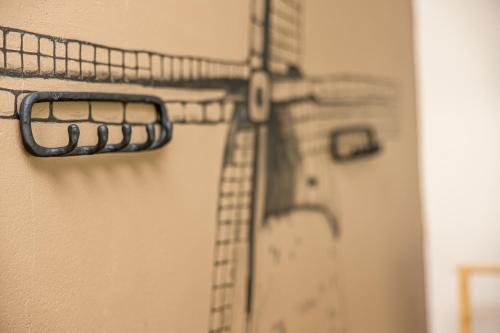 a metal rack on a wall with a clock at Atpūtys in Palanga