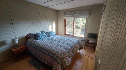 1 dormitorio con cama y ventana en Casa Camino al Volcán en Pucón