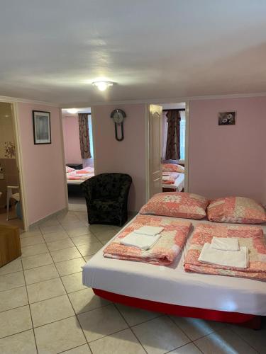 a bedroom with two beds and a living room at Sweet Home Apartman in Hajdúszoboszló