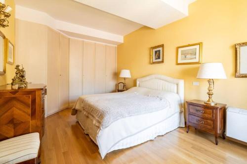 una camera con letto bianco e pavimento in legno di Deliziosa Casa nel Centro di Bologna Palazzo Storico Zambeccari a Bologna