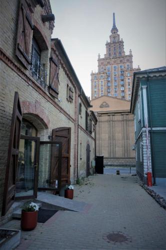 an empty alley in an old building with a clock tower at Urban Van Glamping Riga in Rīga