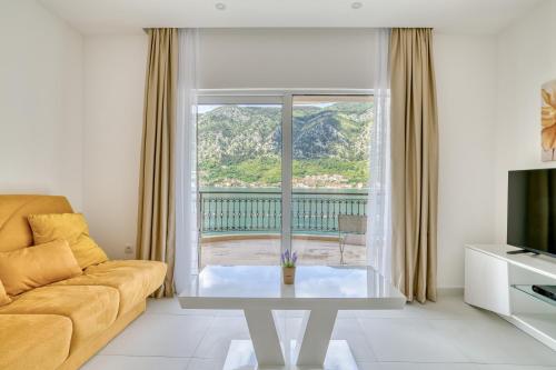 a living room with a couch and a large window at The Golden Luxury Apartments in Kotor