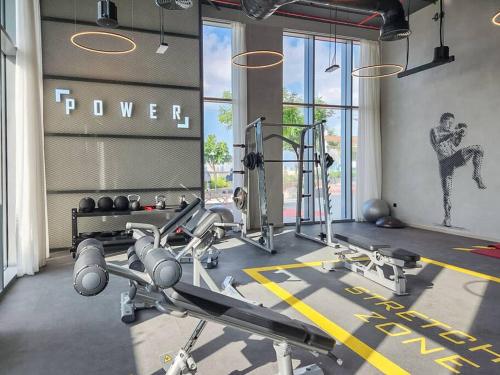 a fitness room with a gym with cardio equipment at Vogue Vacation Homes, Creek Harbour The Grand Waterfront Living close to Downtown, Burj Khalifa and Dubai Mall, Two Bedroom Apartment with Balcony, Canal and Vibrant Community View, Access to all Amenities in Dubai