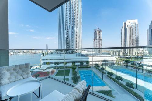 a balcony with a view of a city skyline at Vogue Vacation Homes, Creek Harbour The Grand Waterfront Living close to Downtown, Burj Khalifa and Dubai Mall, Two Bedroom Apartment with Balcony, Canal and Vibrant Community View, Access to all Amenities in Dubai