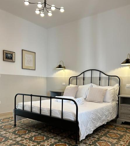 a bedroom with a black bed with white pillows at Caves Garden in Bari