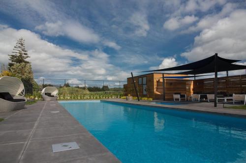 a swimming pool in front of a building at The Green House - Luxury Eco Escape in Martinborough 