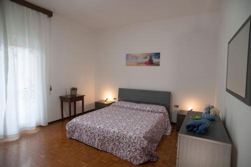 a bedroom with a bed and two tables and a window at Casa Vacanze Mari, Paratico in Paratico