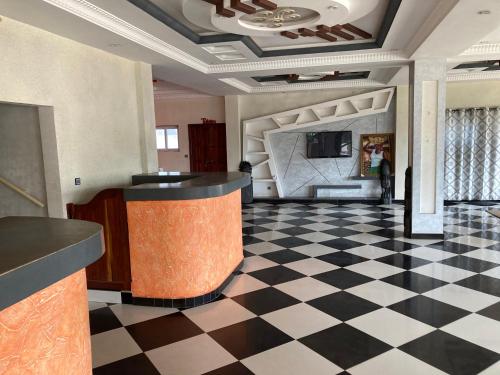 un vestíbulo con suelo a cuadros y un bar en Hotel Bel Azur Grand-Popo, en Nicouécodji