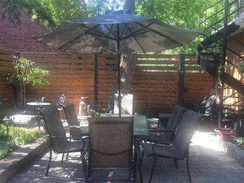 a table and chairs with an umbrella on a patio at Maison Des Jardins B & B in Montréal