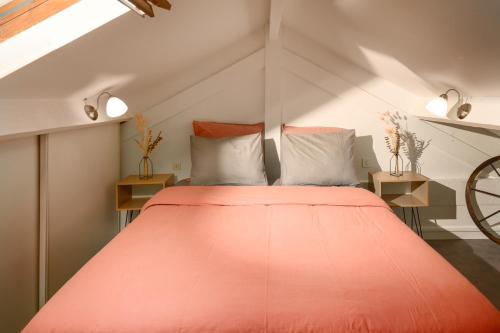 um quarto com uma grande cama laranja num sótão em My Evening Break- Appartement cosy proche Disney et Paris em Noisy-le-Grand
