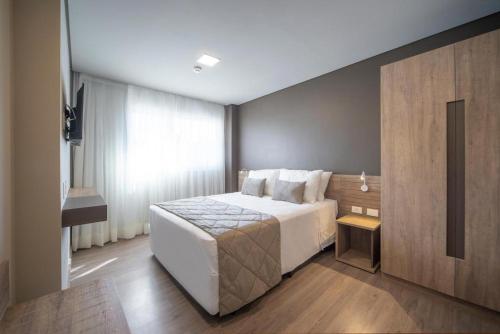 ein Hotelzimmer mit einem Bett und einem Fenster in der Unterkunft Laghetto Resort Golden Gramado - 46 m2 - Vista para o Vale in Gramado