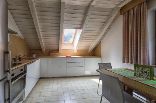 a kitchen with white cabinets and a table and a window at Apartments Markus in Ortisei