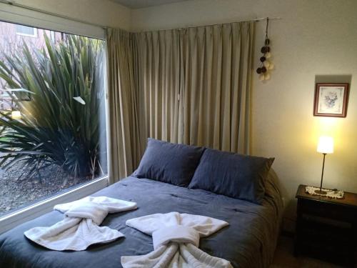 um quarto com toalhas numa cama com uma janela em Alegra Centro em San Martín de los Andes