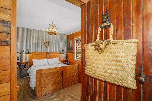 a bedroom with a bed and a purse on the wall at Cosy Central Cottage in Rotorua