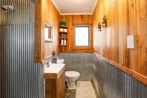 a bathroom with a toilet and a sink at Cosy Central Cottage in Rotorua