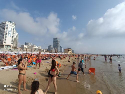 a large group of people on a beach at Private rooms near the beach center in Tel Aviv