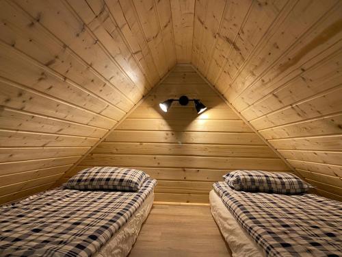 um quarto com 2 camas num quarto de madeira em Domek pod borówką em Staniszów
