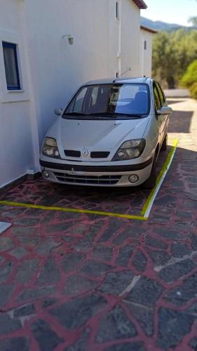 a white car parked in a parking lot at Alexandros Luxury Apartments Nydri in Nydri