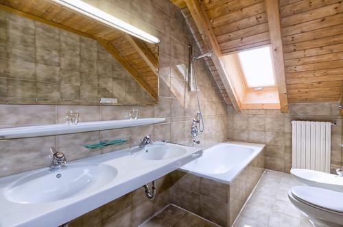 a bathroom with two sinks and a toilet at Apartments Markus in Ortisei