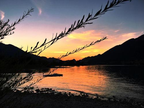 a sunset over a body of water with mountains at Apartment Sunset am Wolfgangsee in Strobl