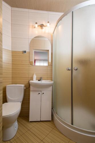 a bathroom with a toilet and a sink and a shower at ADA - pokoje gościnne in Łeba