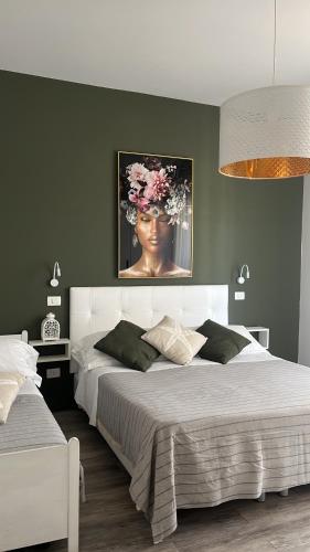 a bedroom with two beds and a painting of a woman at Appartamenti Mar y Sol in Gabicce Mare