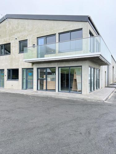 a building with a balcony on the side of it at Stunning Ocean View Penthouse Apartment in Øravík