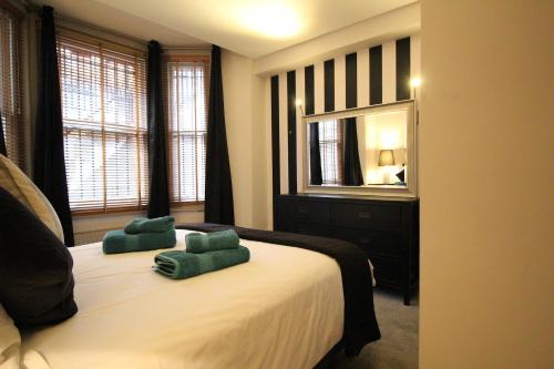 ロンドンにあるThe Bromptons, Luxury South Kensington Apartmentのベッドルーム1室(緑の枕2つ付)