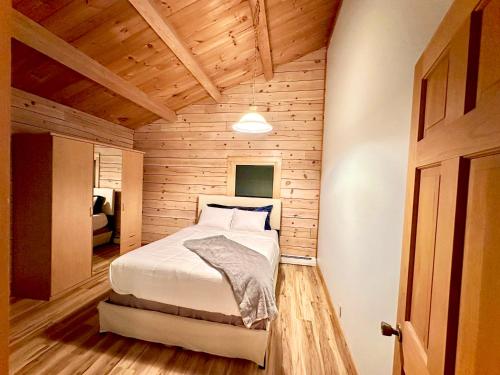 una camera con un letto in una stanza con pareti in legno di Big Bear Cabin a Corning
