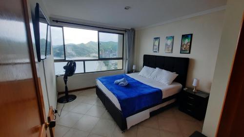 um quarto com uma cama e uma grande janela em El Peñon del Rodadero - Apto 1303A em Santa Marta