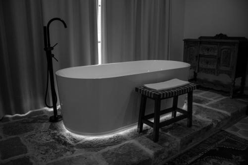 a white bath tub with a stool in a bathroom at Casa 1810 Parque Hotel Boutique in San Miguel de Allende