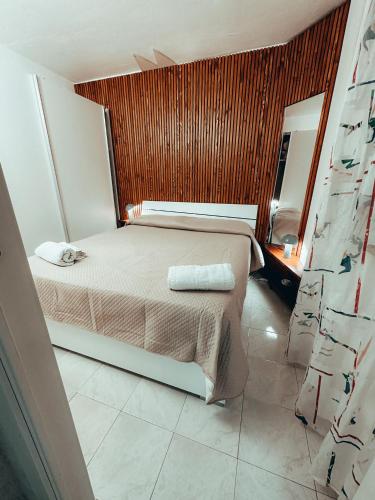 a bedroom with a bed with a wooden wall at Da Paolo e Antonietta in Mazara del Vallo
