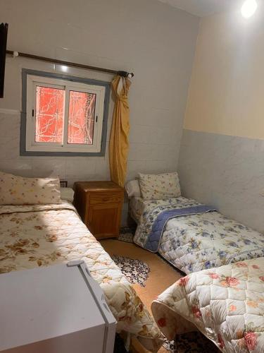 a room with two beds and a window at Hôtel Restaurant ASGAOUR in Amlouggui