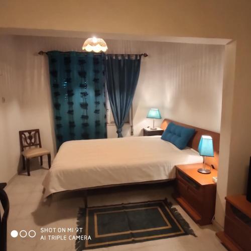 ein Schlafzimmer mit einem Bett und einem blauen Vorhang in der Unterkunft Quinta da Avó in Moncarapacho