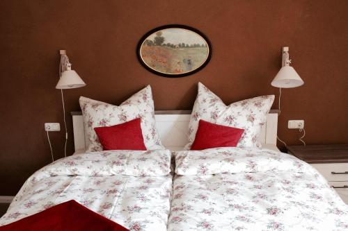 um quarto com 2 camas com almofadas vermelhas e um espelho em Landhaus Weserbergland - Elsa em Vahlbruch