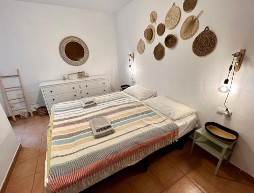 een slaapkamer met een bed, een ladekast en een spiegel bij Casa Teahupoo in Cotillo