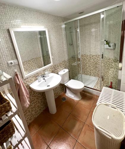 a bathroom with a toilet and a sink and a shower at Casa Teahupoo in El Cotillo
