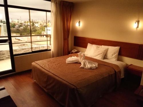 Una habitación de hotel con una cama con toallas. en Hostal Qoyllurwasi, en Arequipa